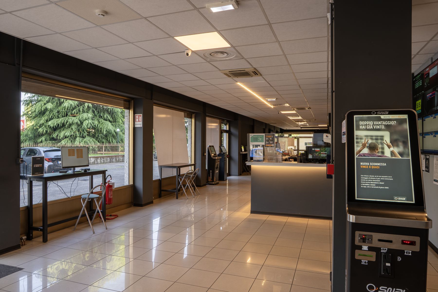 Interno agenzia scommesse con schermi sportivi
