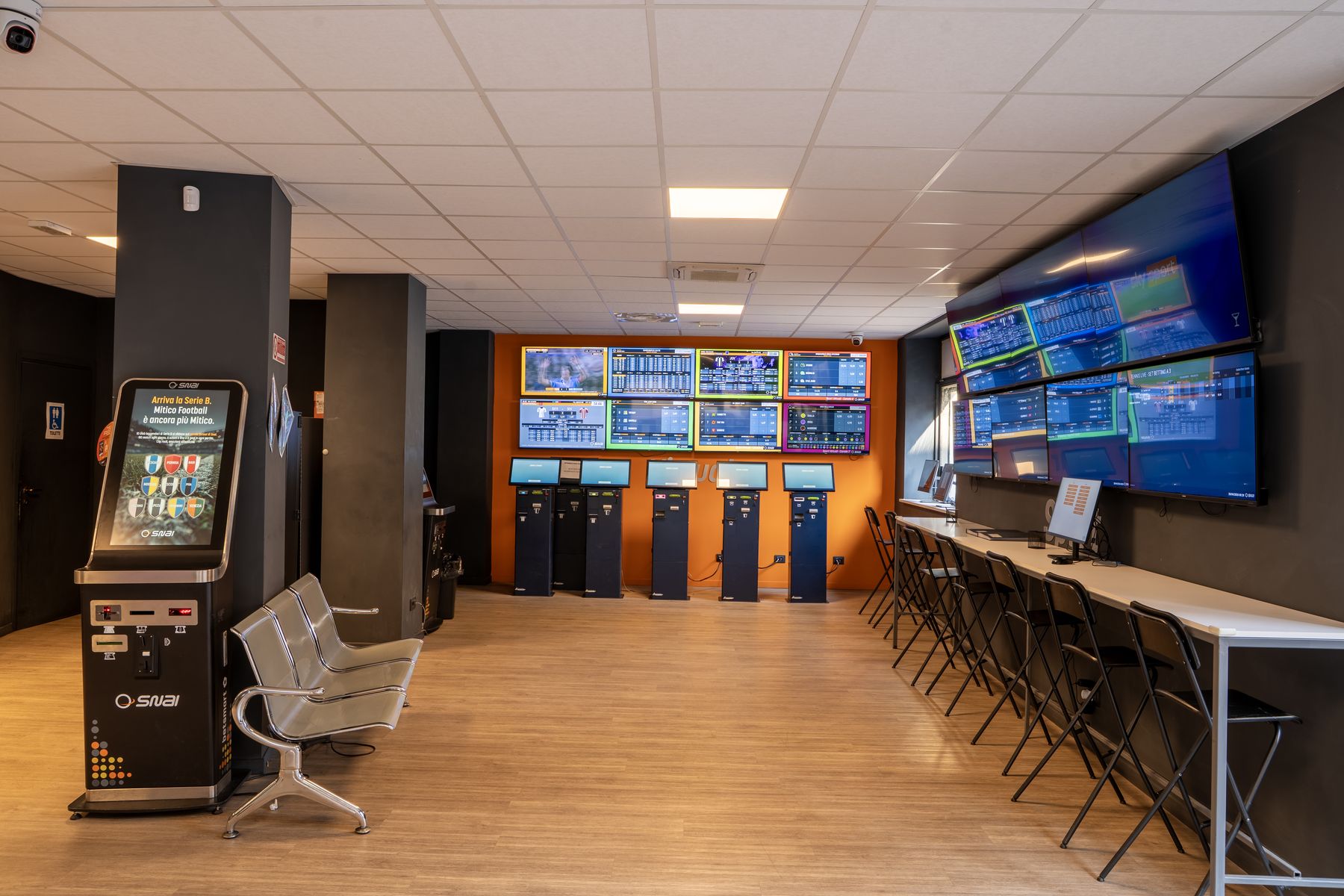 Interno agenzia scommesse con schermi sportivi