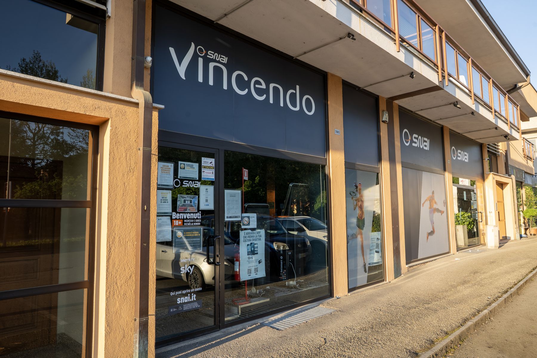 Interno agenzia scommesse con schermi sportivi